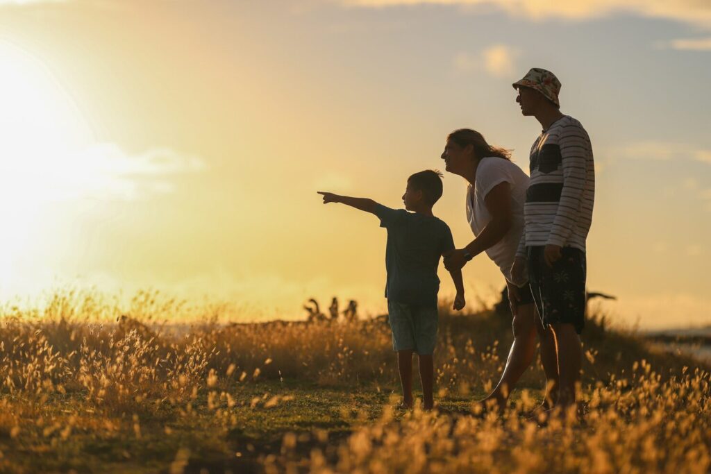 Family in silhouette in field. child pointing. Bel Gamlin Counselling in Bradford on Avon